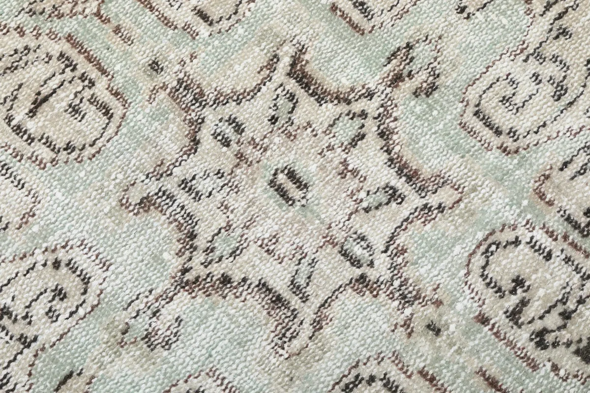 Macro detail of the hand-knotted wool pile and the intricate geometric weave of the medallion