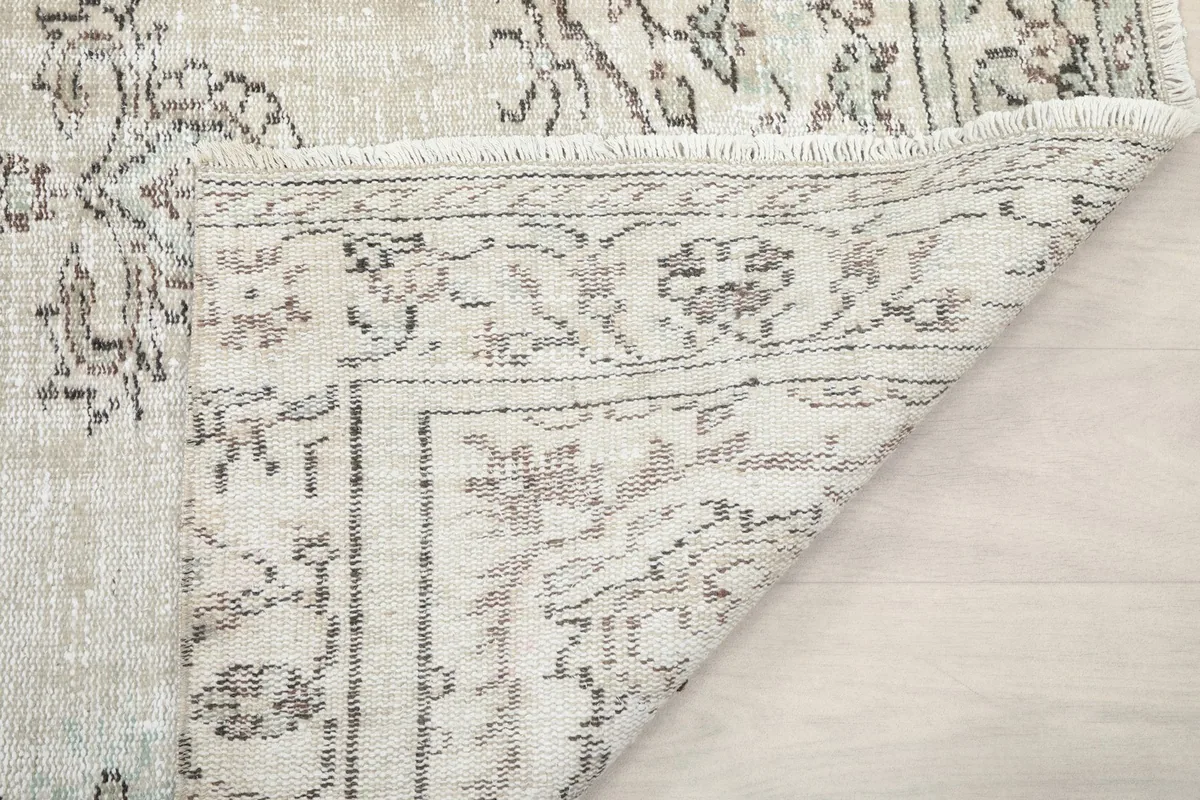 Another view of the rug corner folded, revealing the tight hand-knotting and fringe detail