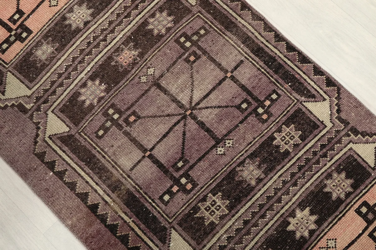 Close-up of the central purple geometric motif and surrounding border details