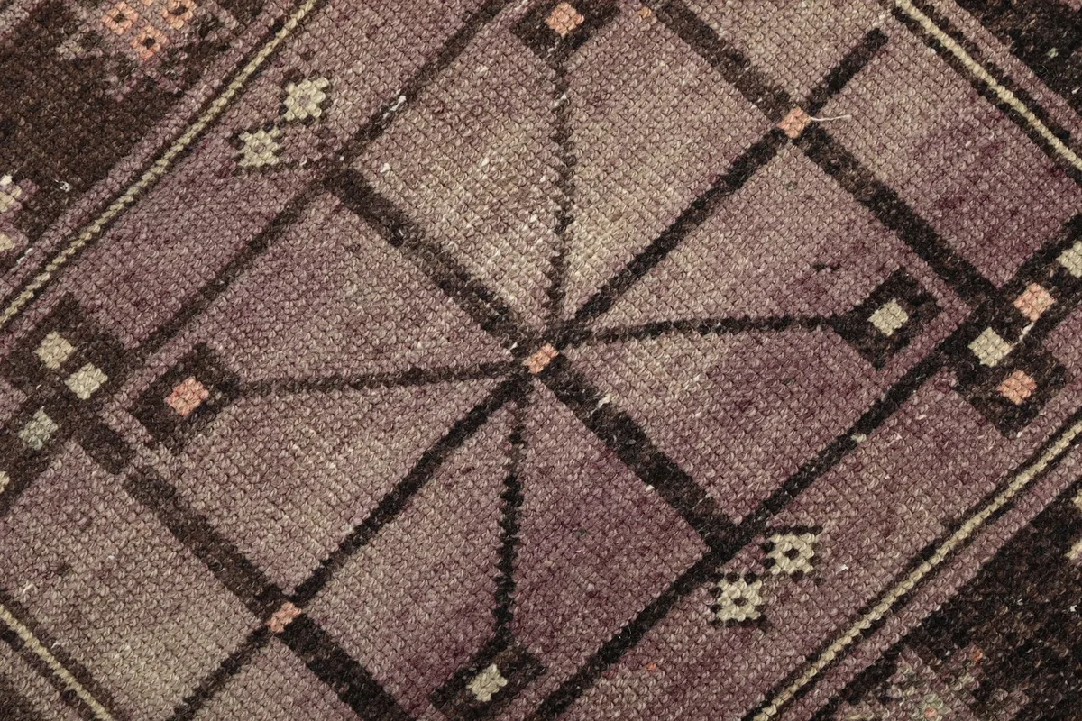 Macro shot of the wool pile, showing the texture and color variations in the purple section