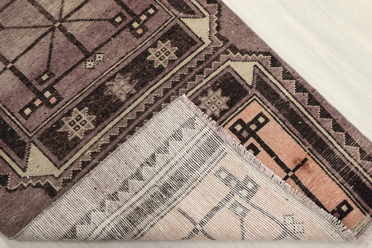 Underside of the runner rug, showing the hand-knotted cotton foundation and fringe