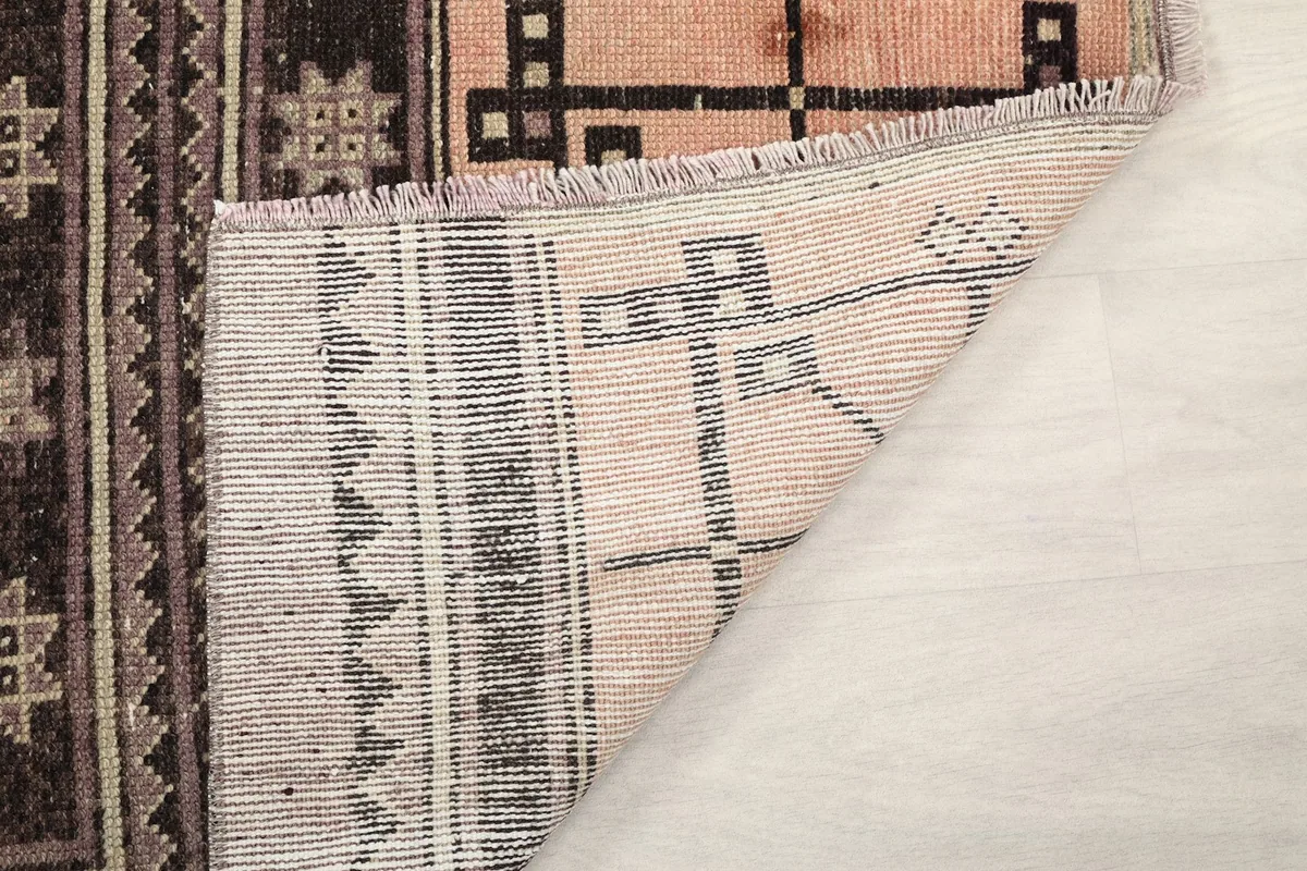 Close-up of the rug's back, revealing the knotting structure and fringe detail