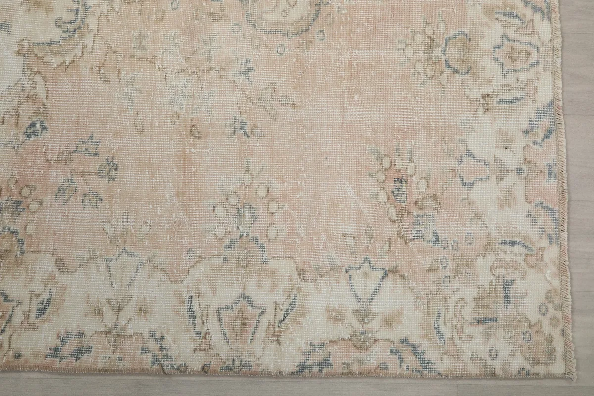 Detailed view of the rug's border and corner, revealing the intricate floral-geometric patterns and gray accents.