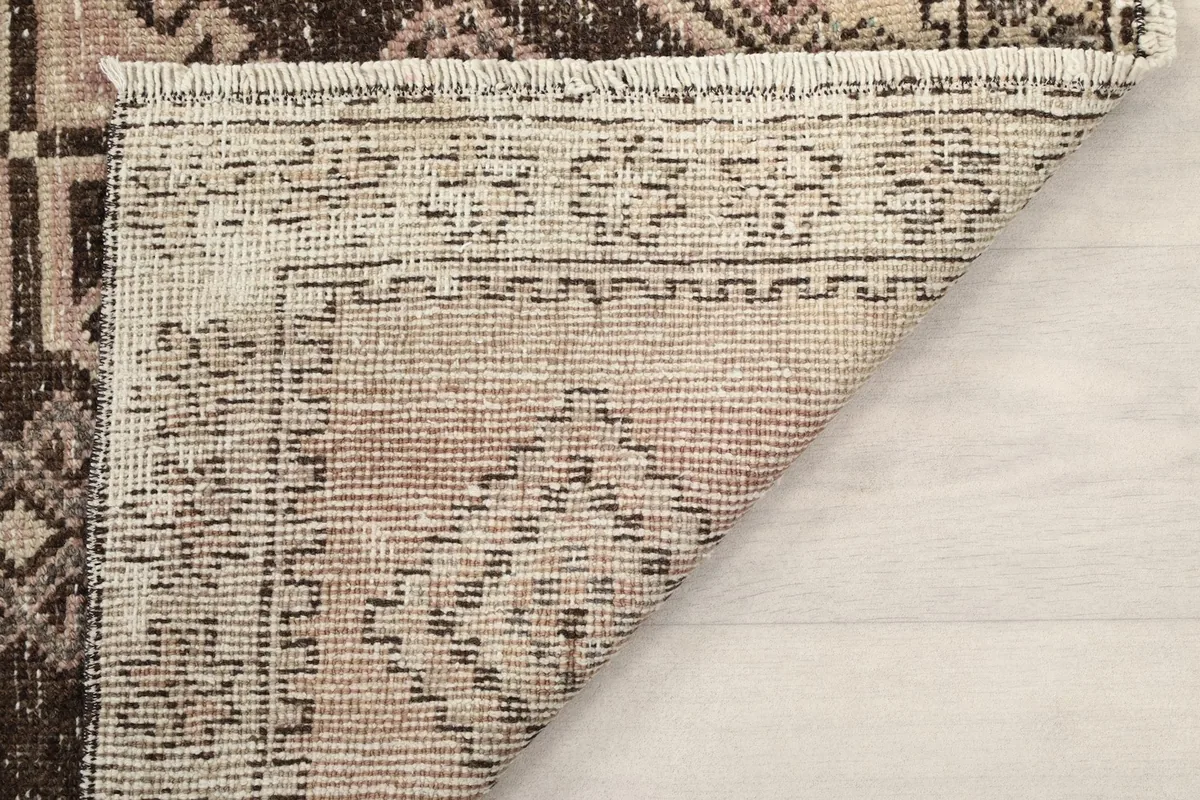 Close-up of the back of the rug, showing the knotting structure and the natural fibers.