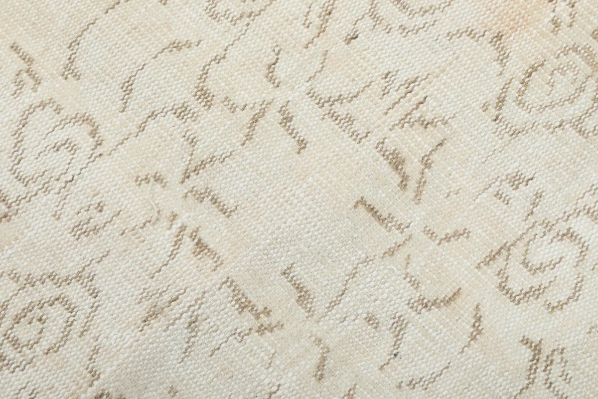 Texture and low pile of the hand-knotted wool rug, showing subtle wear