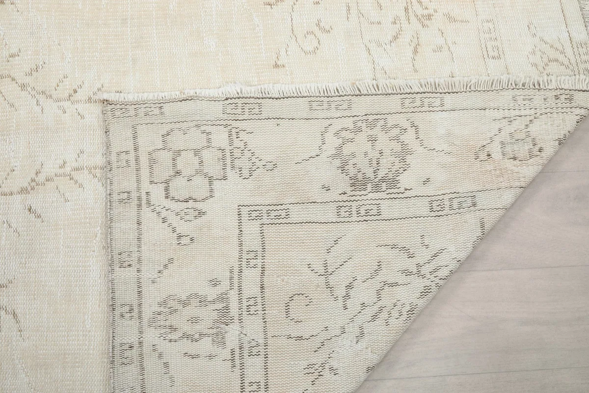 Corner of the rug lifted to show the reverse side and knotting detail