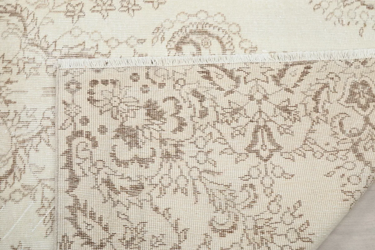 Close-up of the rug's edge and fringe, along with the hand-knotted foundation