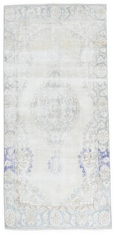 Full overhead view of the 4'5" x 8'5" ivory and blue vintage Anatolian area rug on a white background.