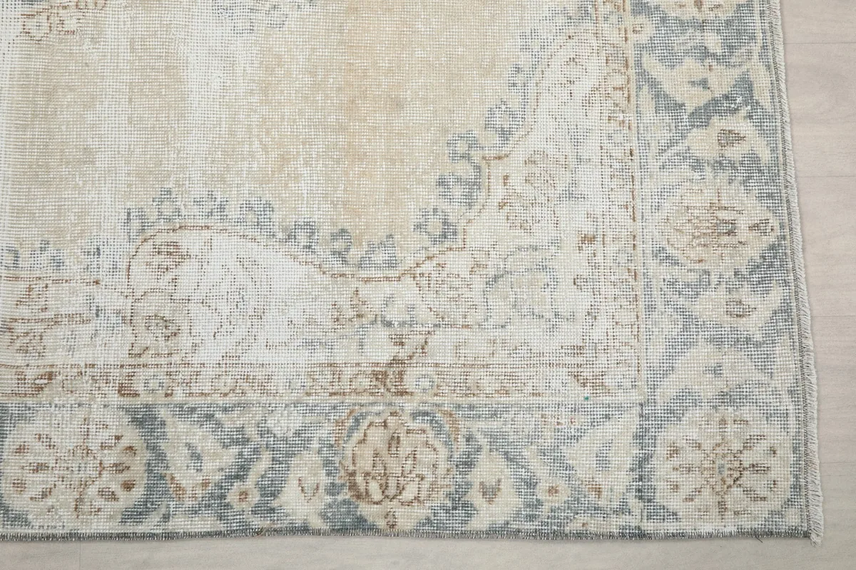 Detailed view of the rug's blue border with intricate floral and geometric patterns.