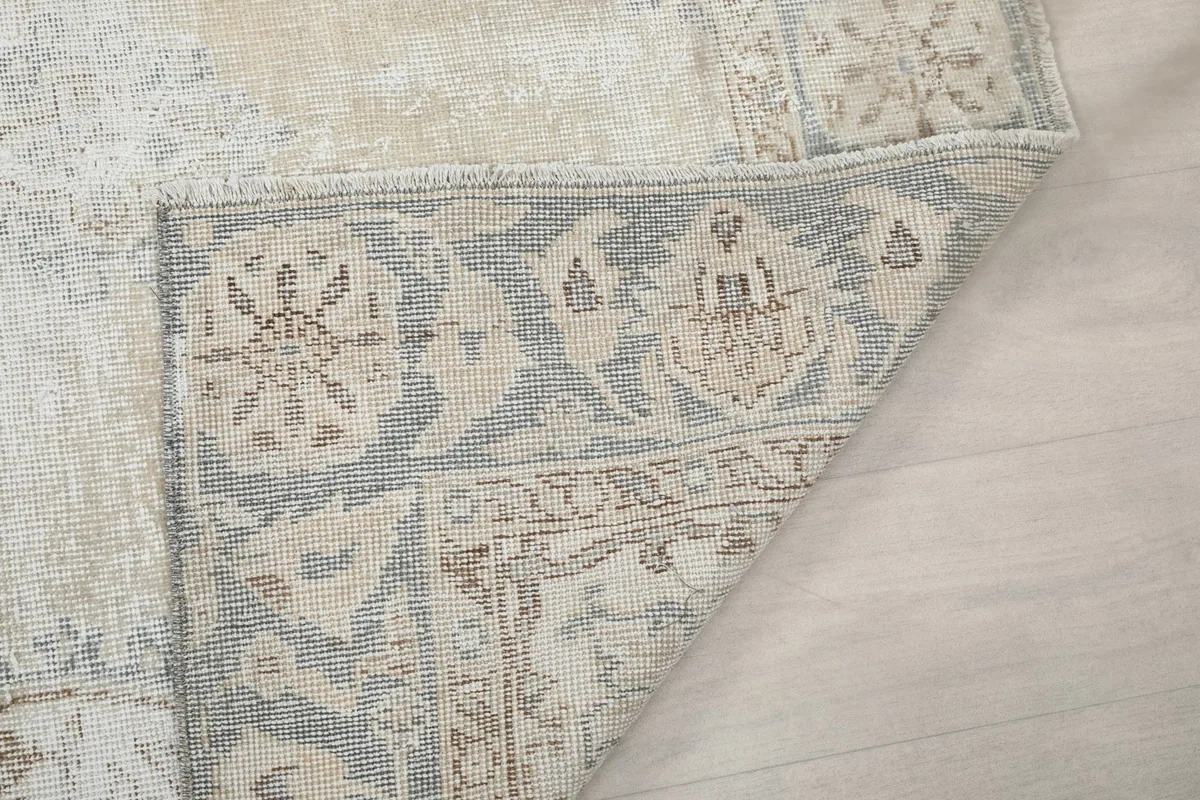 Close-up of the rug's underside, revealing the tightly woven cotton foundation and knotting details.
