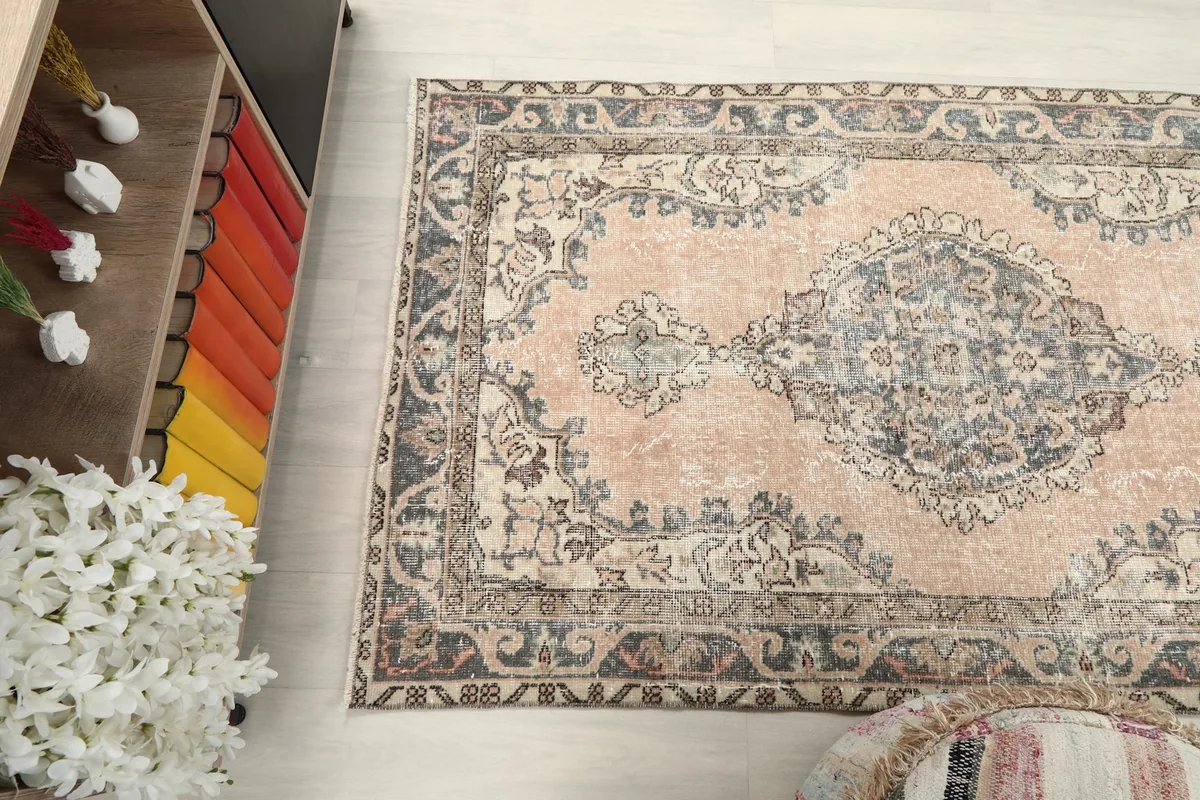 Diagonal view of the rug, emphasizing its shape and the interplay of rose and gray colors