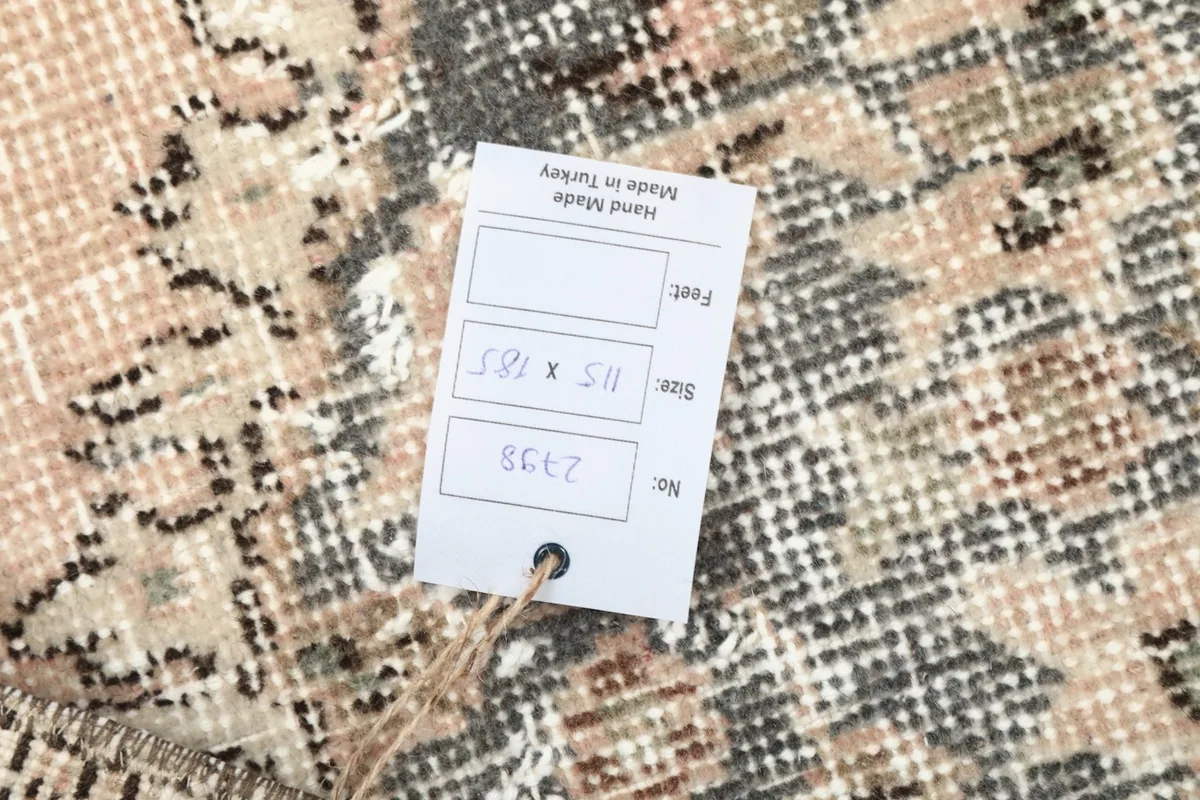 Product tag on the rug, displaying size in centimeters and feet, and origin as Hand Made in Turkey
