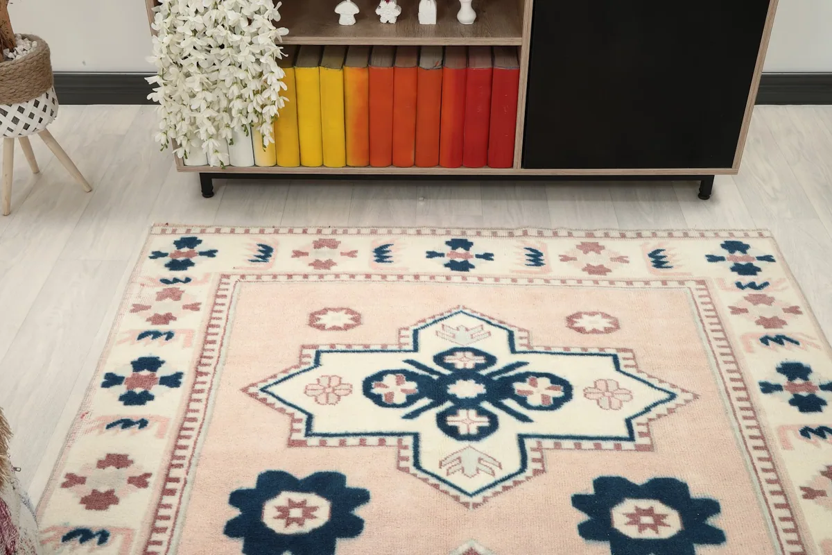 Overhead angle view of the rose and navy rug, showing its full design and colors