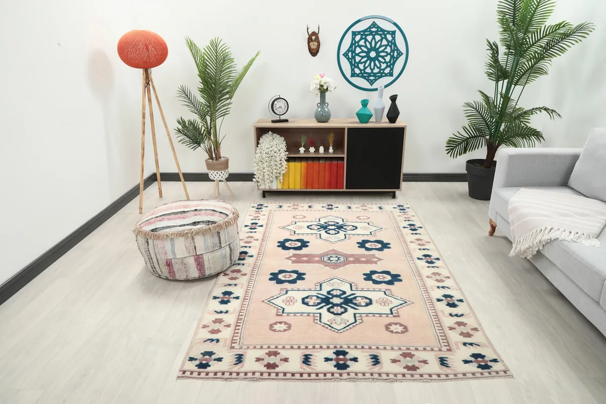 Rose and navy tribal rug in a modern living room setting with plants and furniture