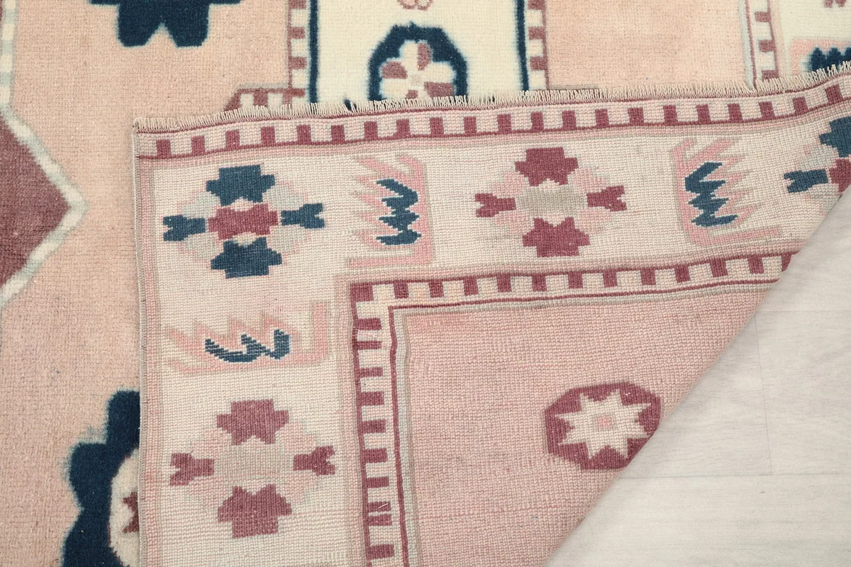 Close-up of the folded rug edge, showing the pile and the cotton foundation
