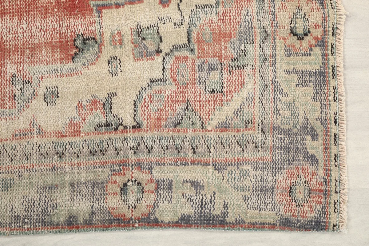 Detailed view of the corner of the vintage Anatolian rug, highlighting the gray border and motifs
