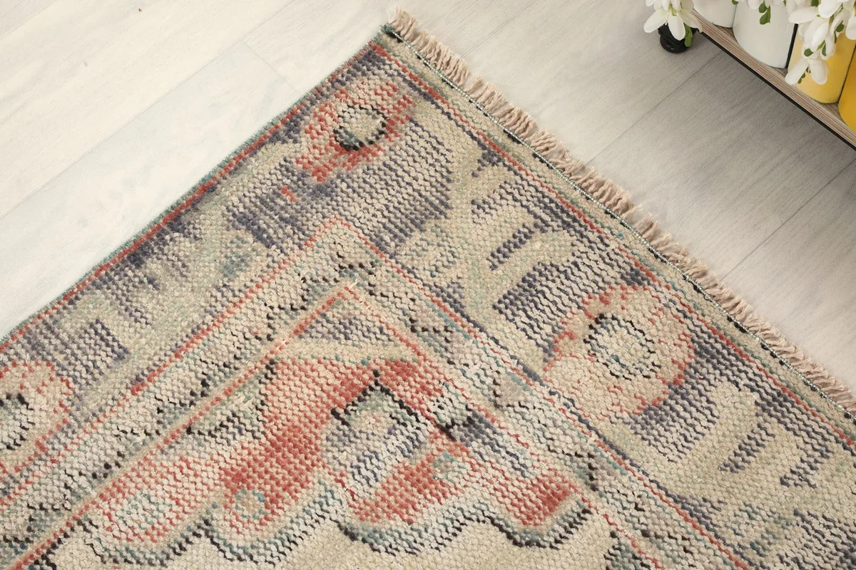 Close-up of the rug's border and corner, showing the hand-knotted detail and colors