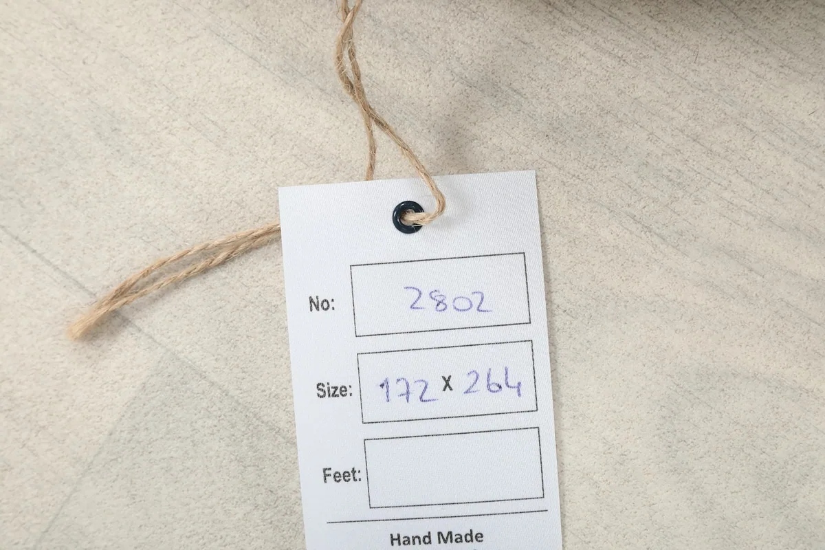 Close-up of the product tag showing the rug's dimensions in centimeters