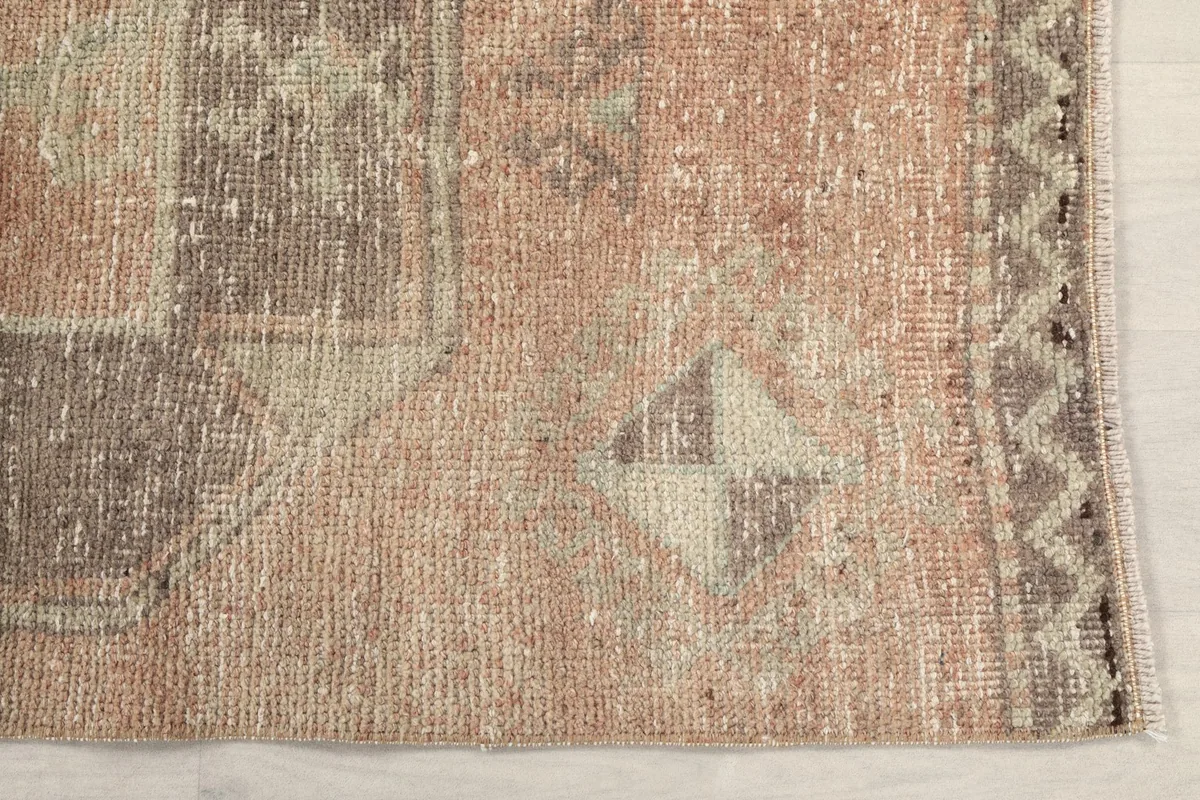 Detailed view of the rust field and gray geometric patterns on the rug's surface