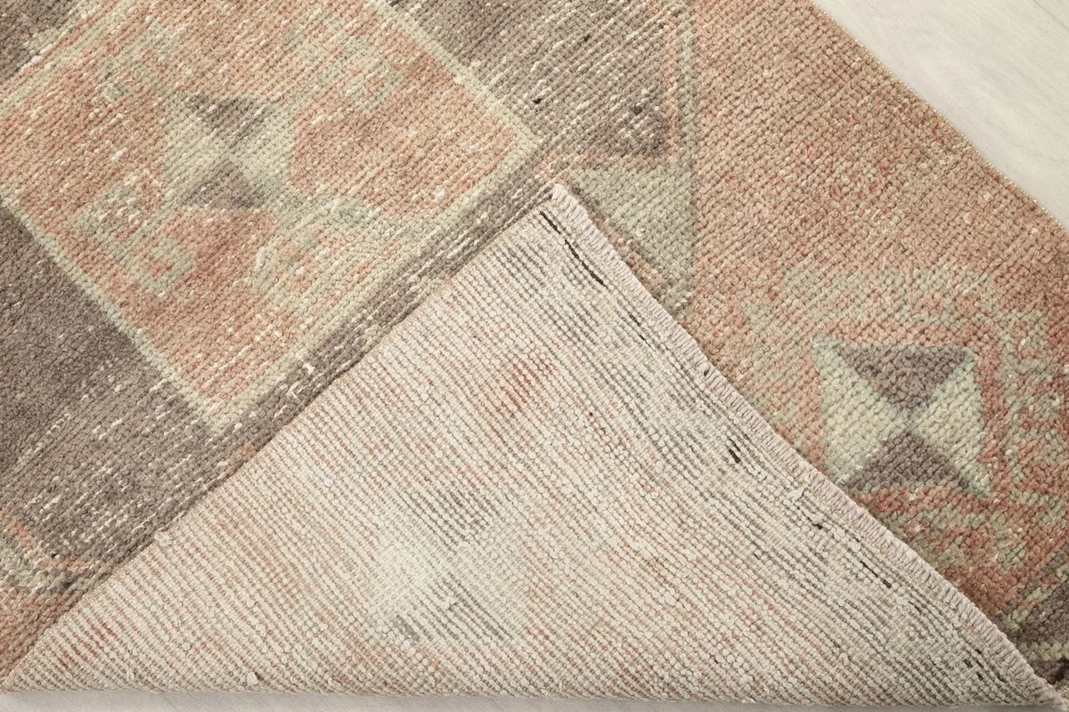 Corner of the hand-knotted rug folded to show the cotton foundation and back weave