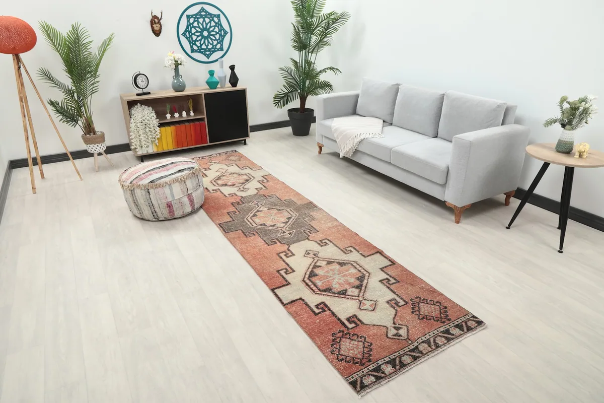 Angled view of the rust runner rug in a room, highlighting its geometric design and scale