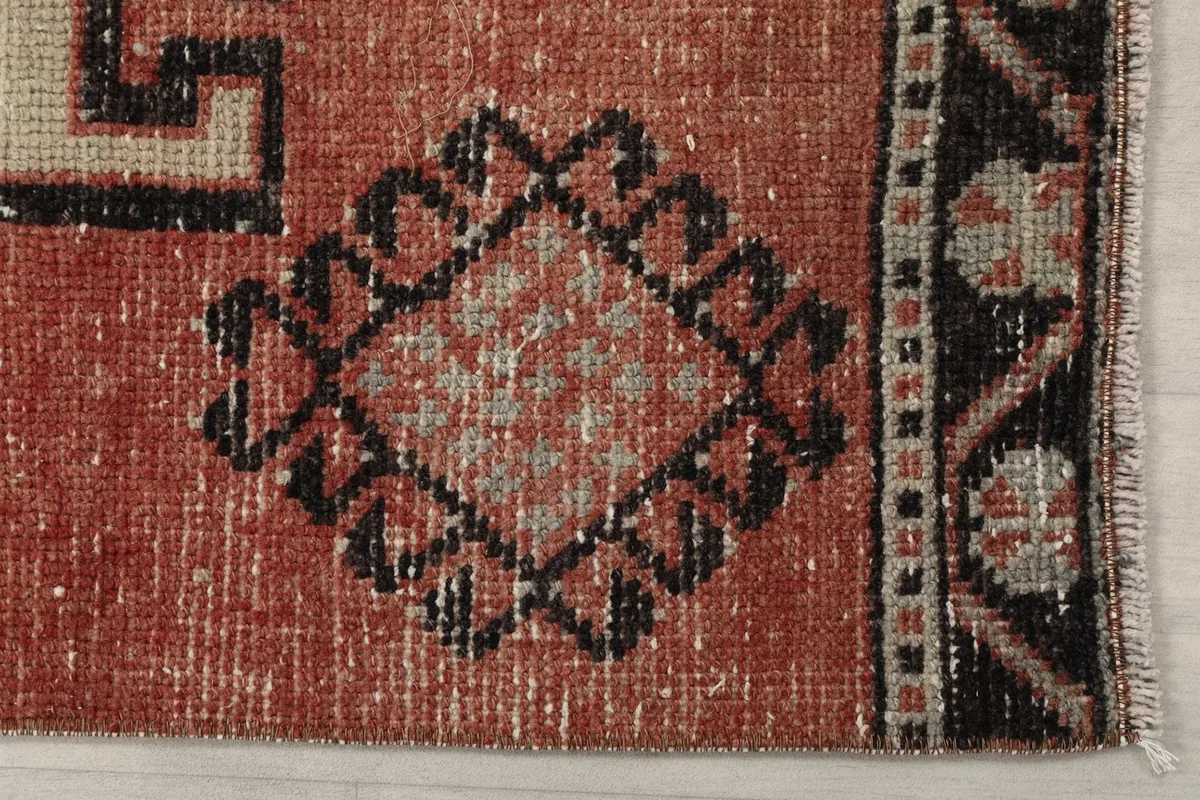 Detailed view of the rust field and a small geometric motif near the border of the runner