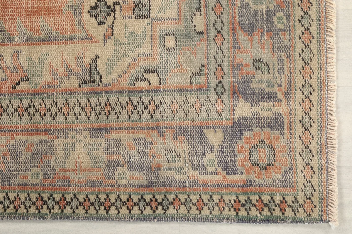 Detail of the rug's border design, showing geometric patterns and fringe