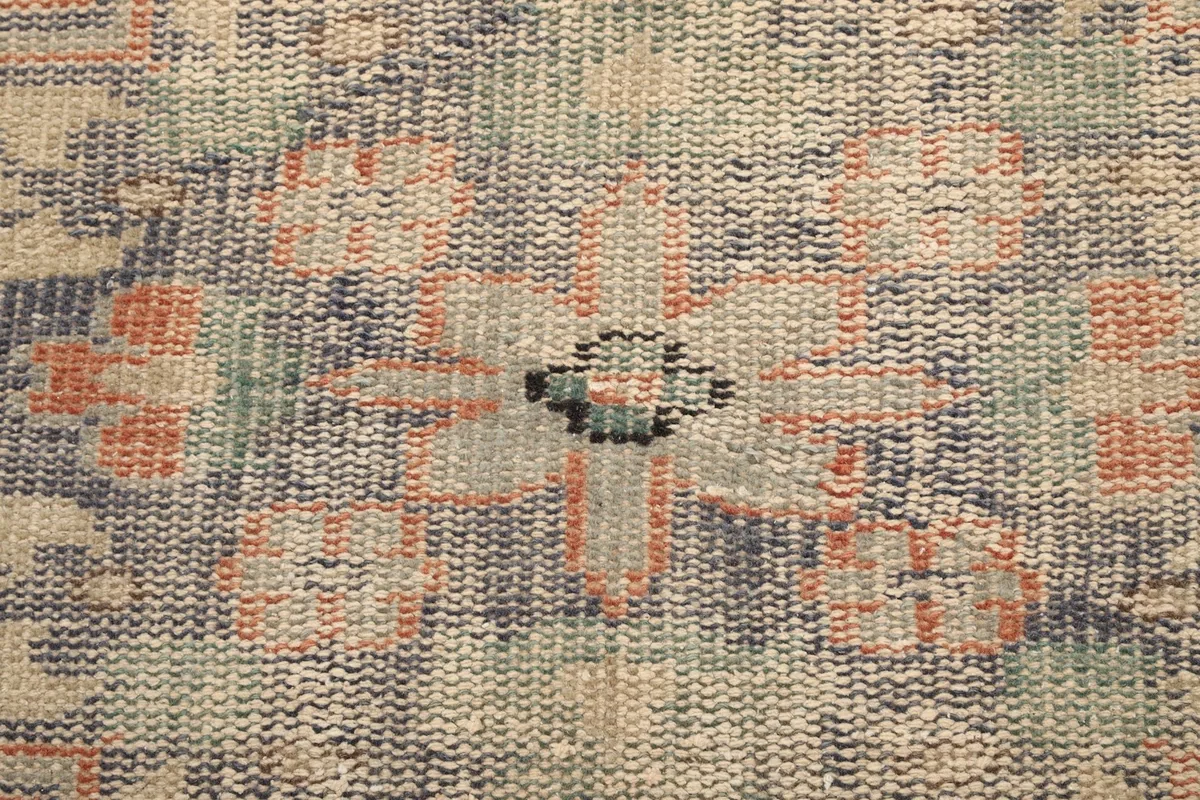 Macro shot showing the low wool pile and intricate knotting of the rug