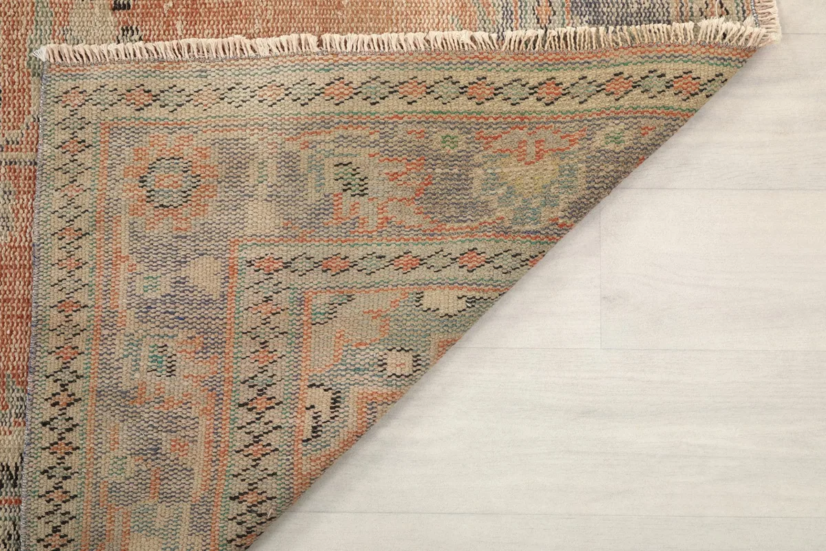 Another view of the rug's back, showing the construction and a glimpse of the front