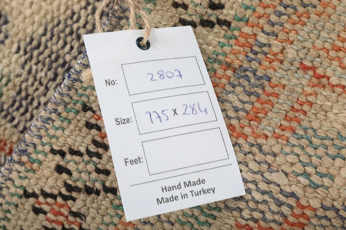 Close-up of the product tag indicating hand-made origin and size in centimeters