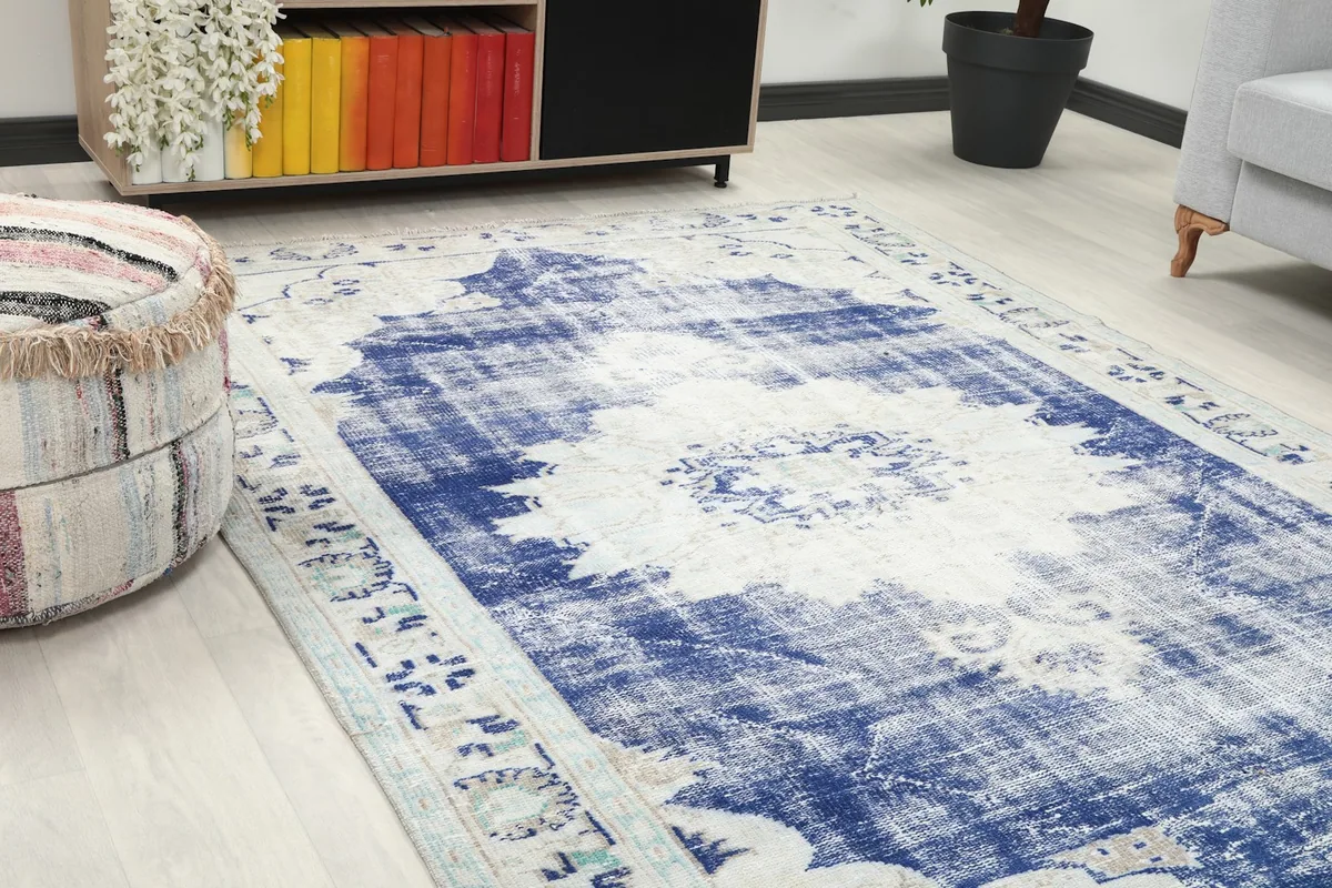 Close-up angle showing the distressed blue field and ivory border of the rug