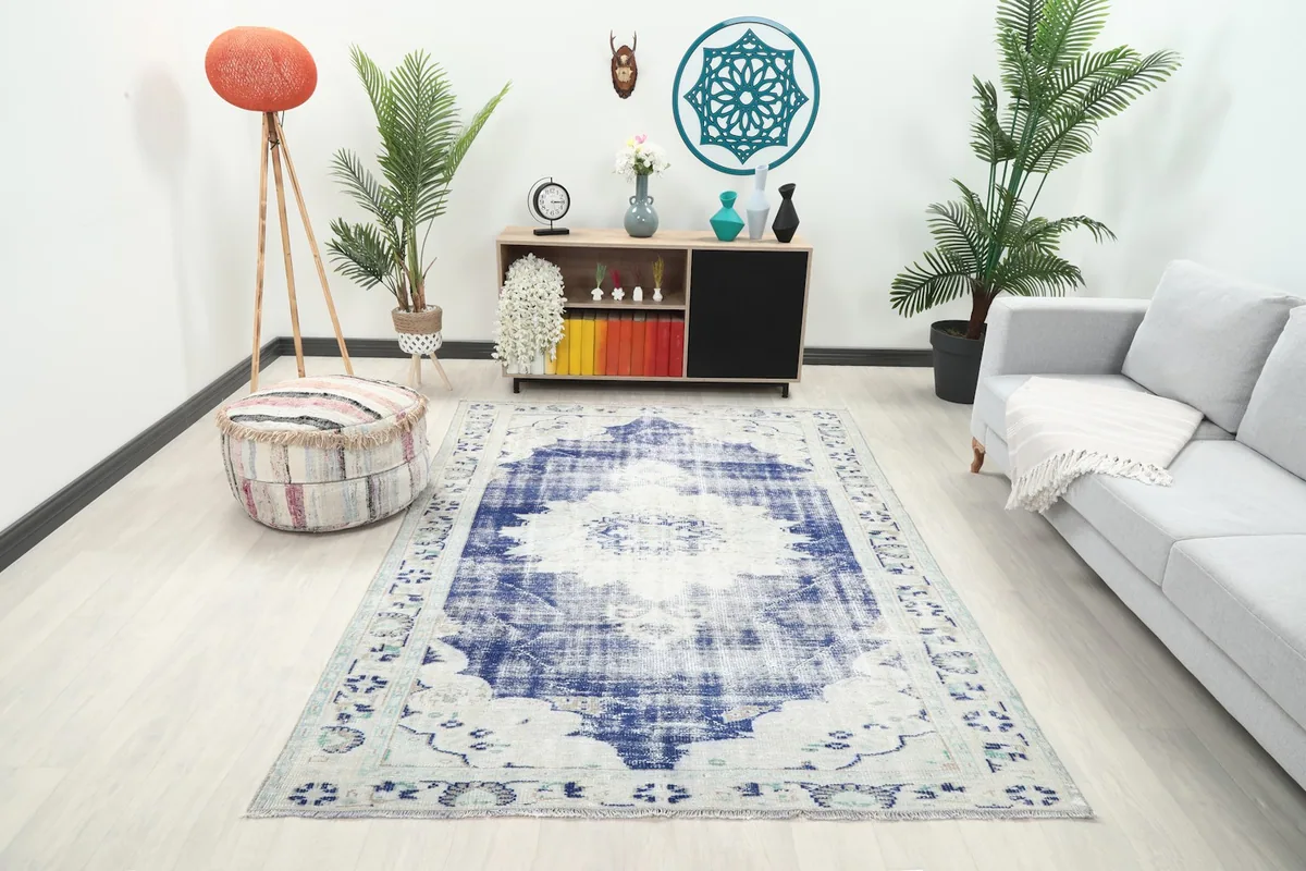 Vintage blue and ivory rug displayed in a bright living room setting