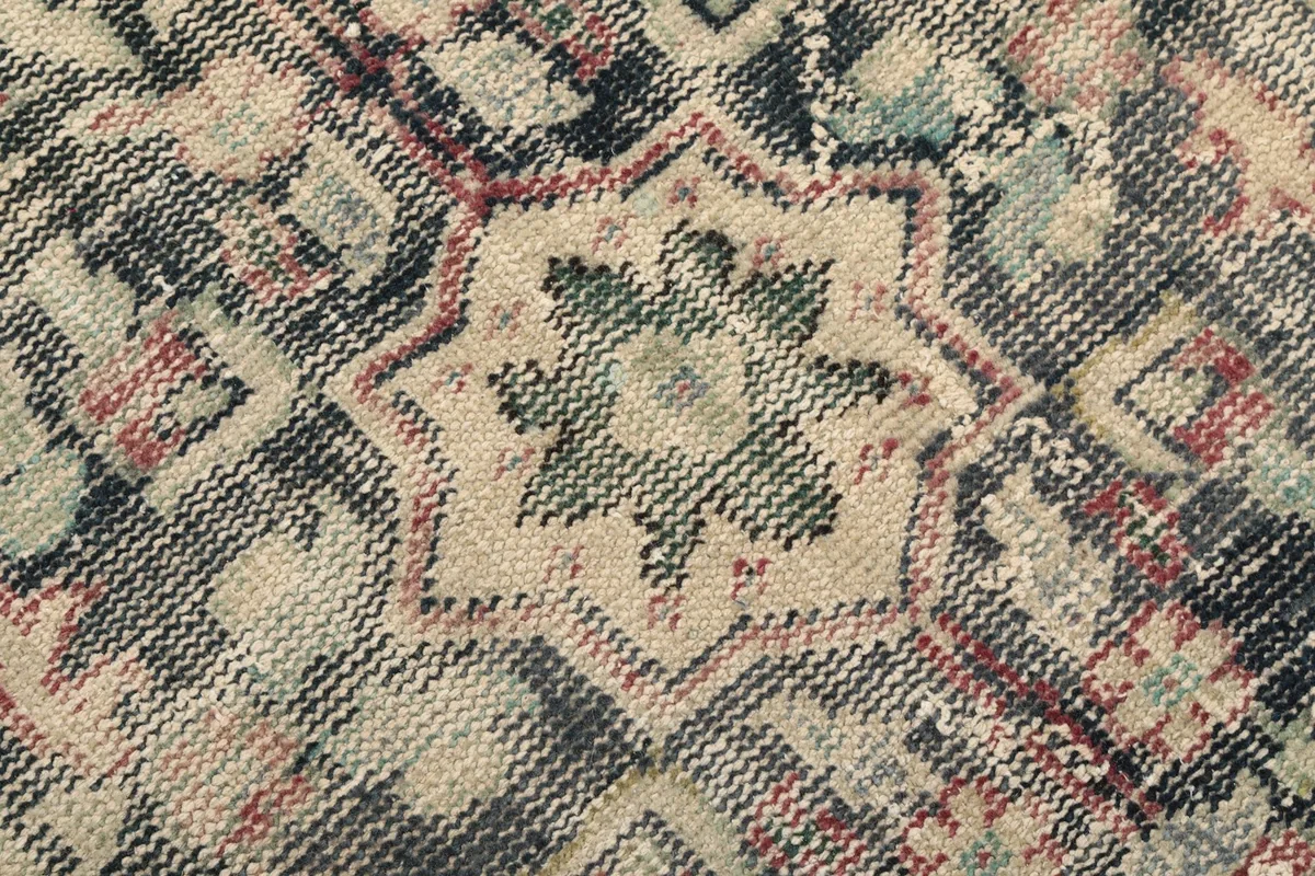 Close-up showing the low pile and intricate knotting of the rug's central design.
