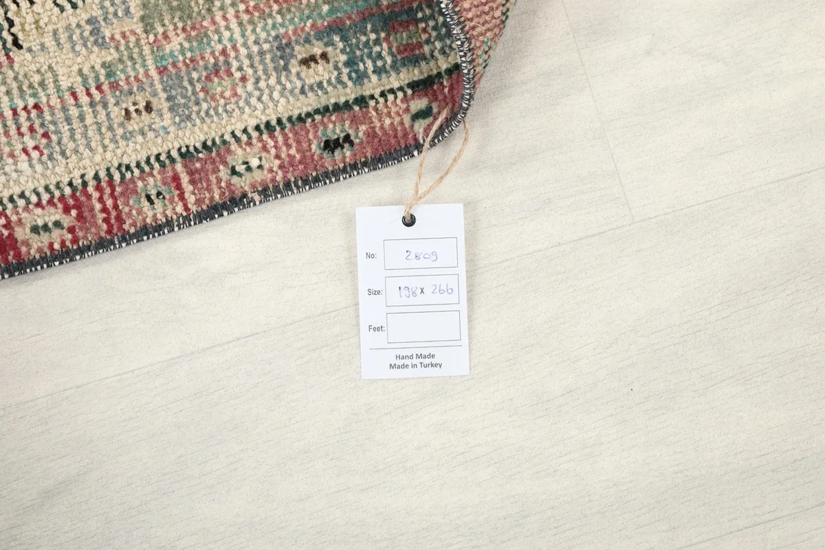 Product tag indicating the rug is hand-knotted and made in Turkey, next to a folded edge.