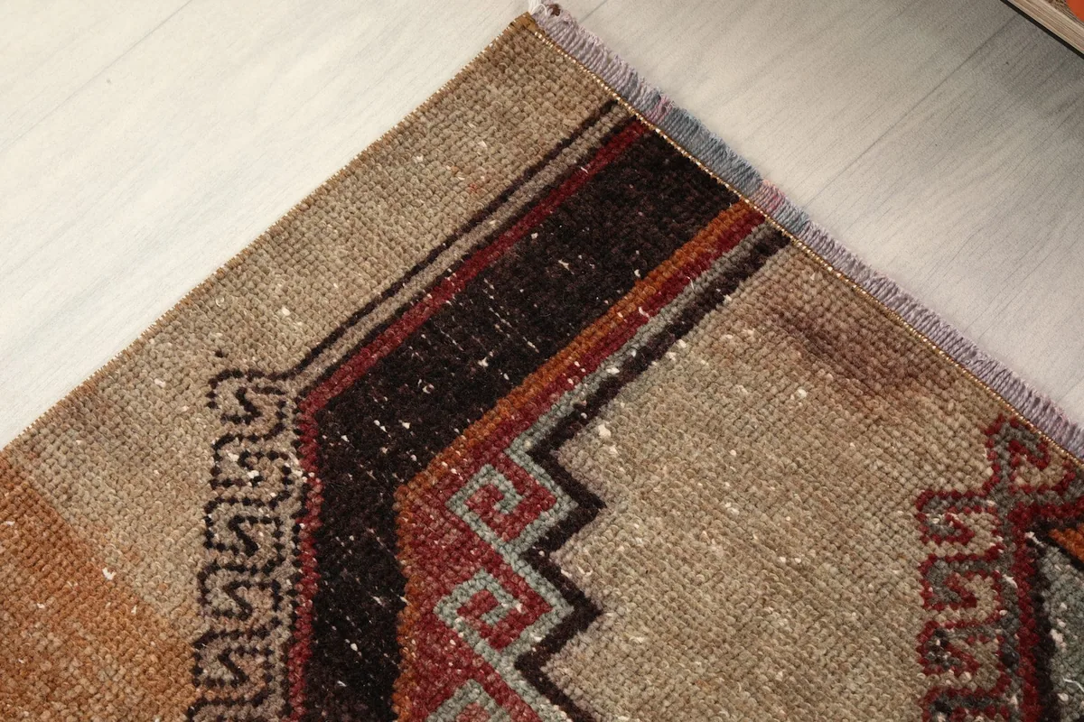 Close-up of the rug's border design, showing the intricate geometric patterns and colors.
