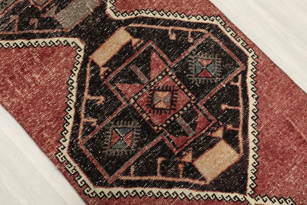 Close-up of a central geometric diamond motif with beige and olive accents
