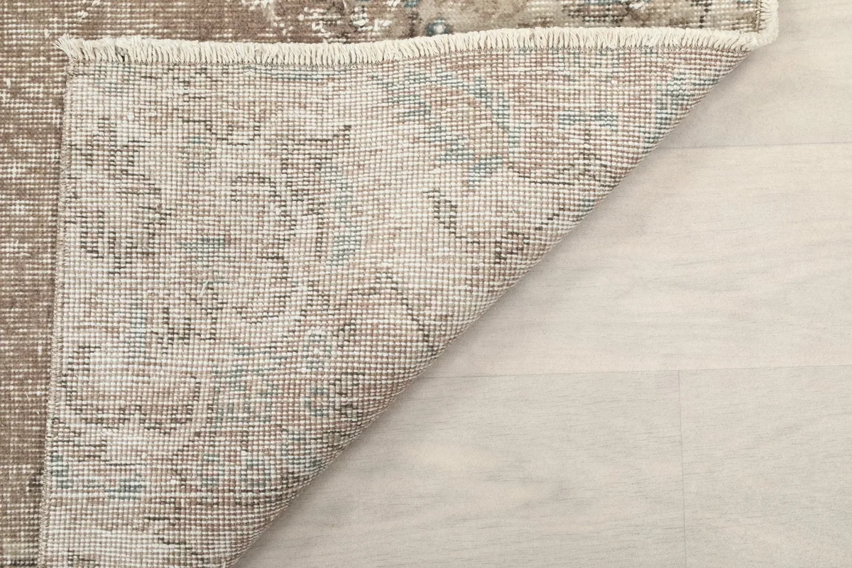 Corner view of the rug's back, showing the tight hand-knotting and fringe detail