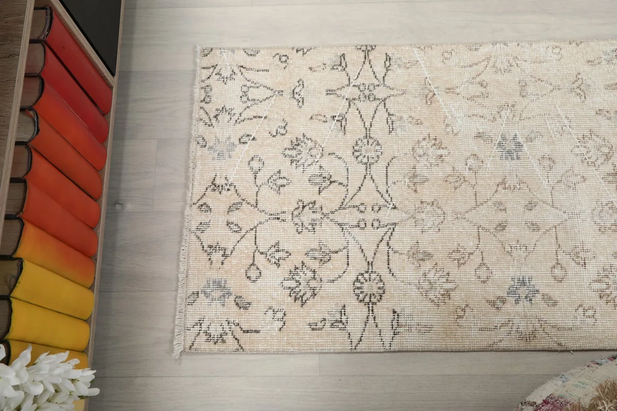 Angled view of the rug's length, showing the repeating floral and geometric patterns