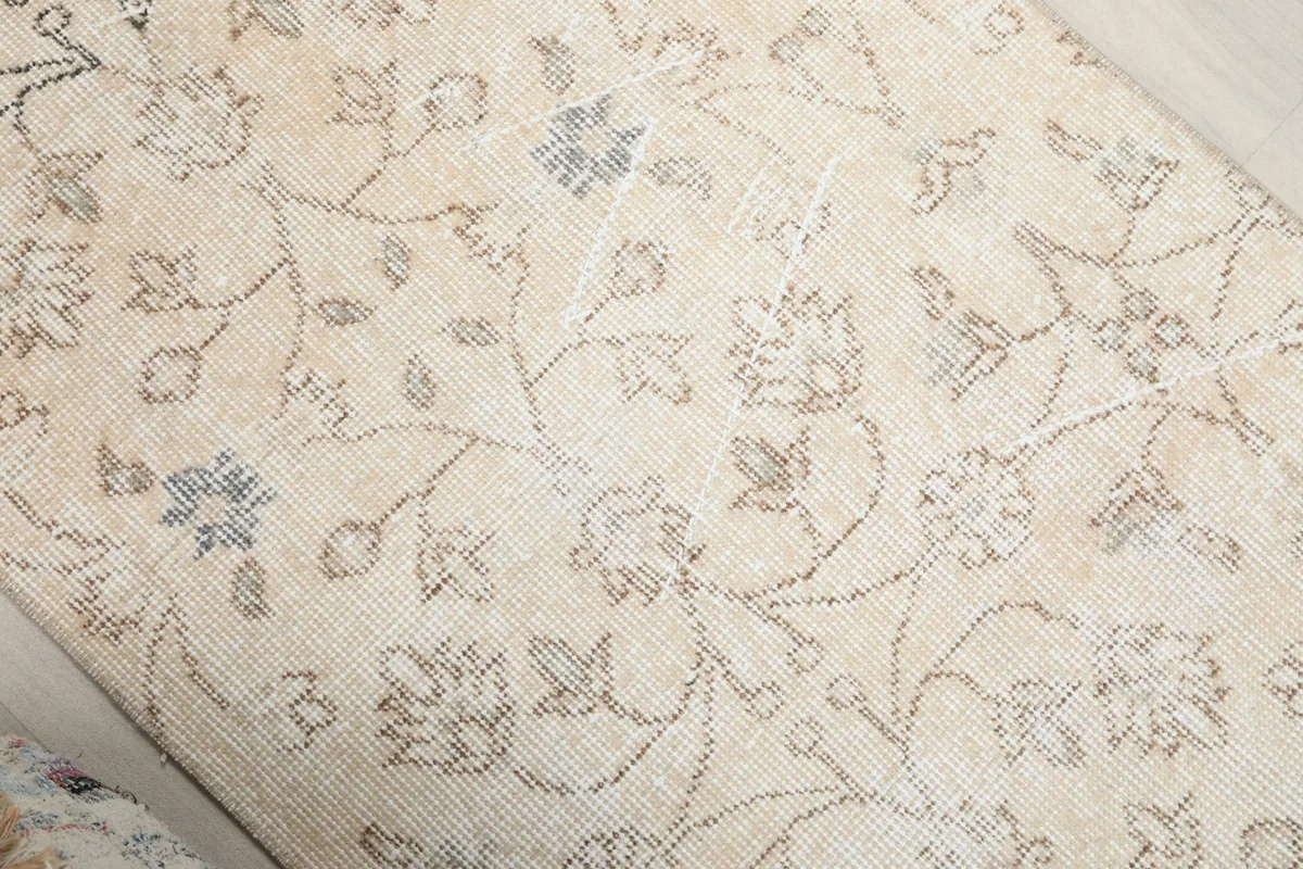 Close-up showing the subtle blue and gray floral patterns and wool pile
