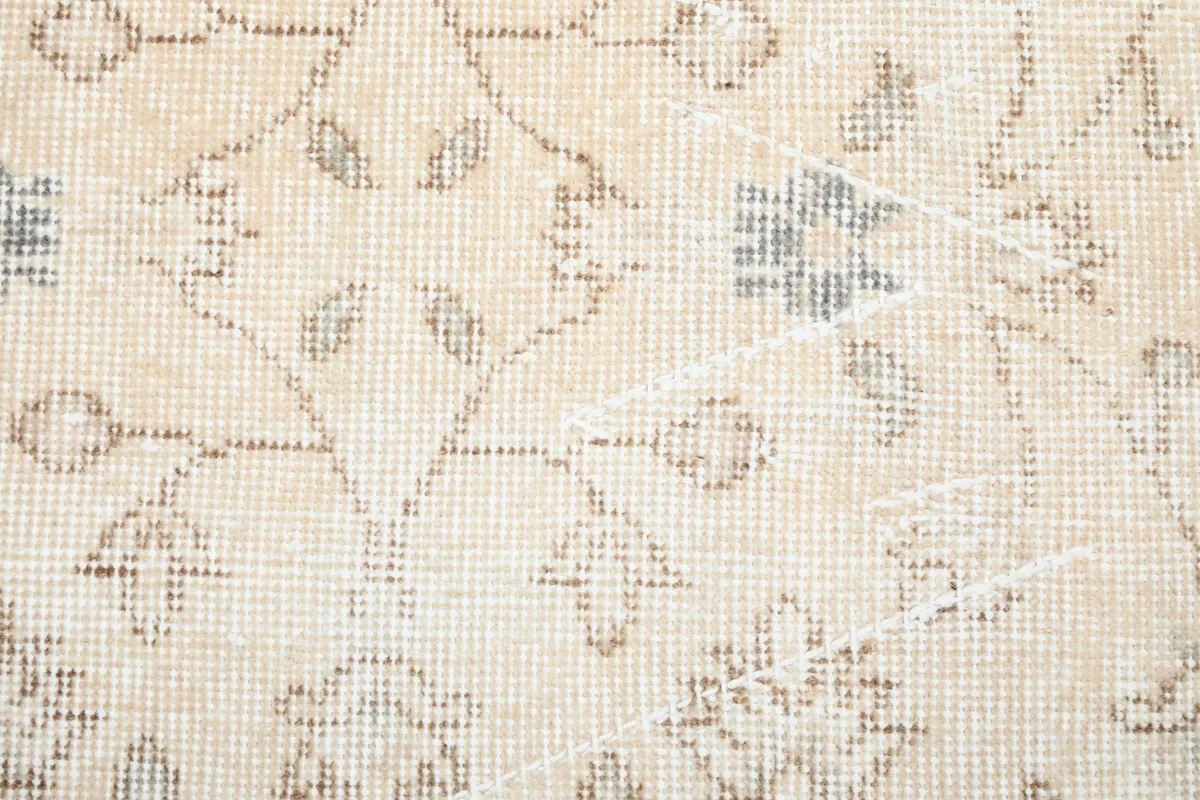 Close-up of the low pile texture and faded floral design of the vintage rug
