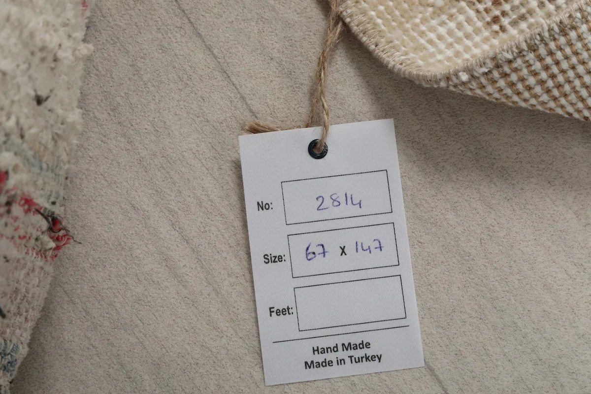 Tag showing the rug's size in centimeters and confirmation of hand-made origin