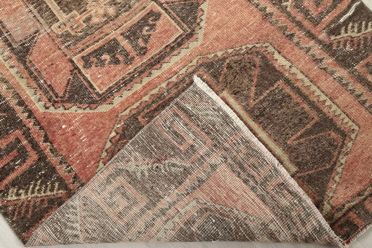 Folded corner of the rug revealing the hand-knotted wool pile and cotton foundation