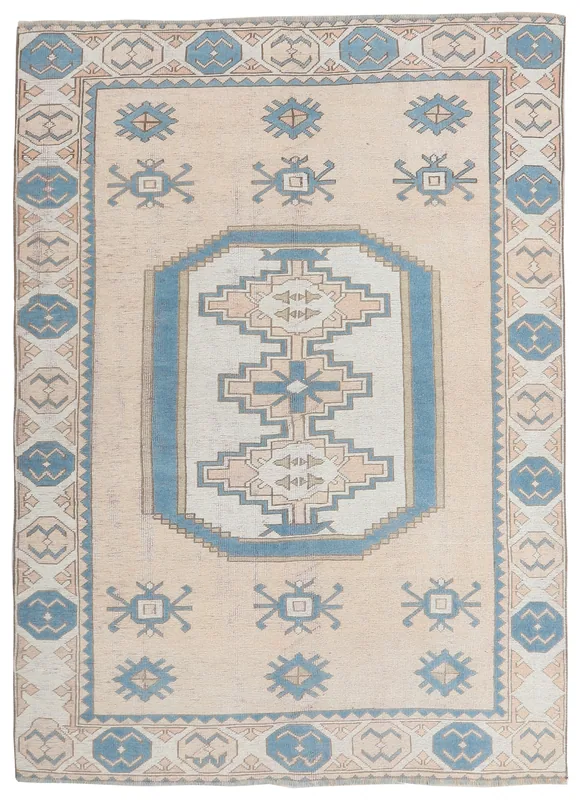 Full top view of the beige and blue Anatolian vintage rug on a white background