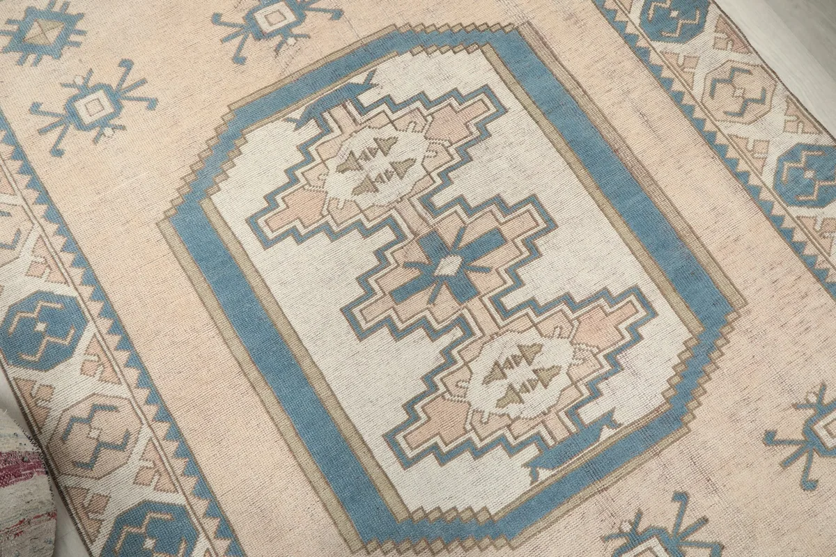 Angled detail of the central medallion with blue, beige, and tan geometric patterns