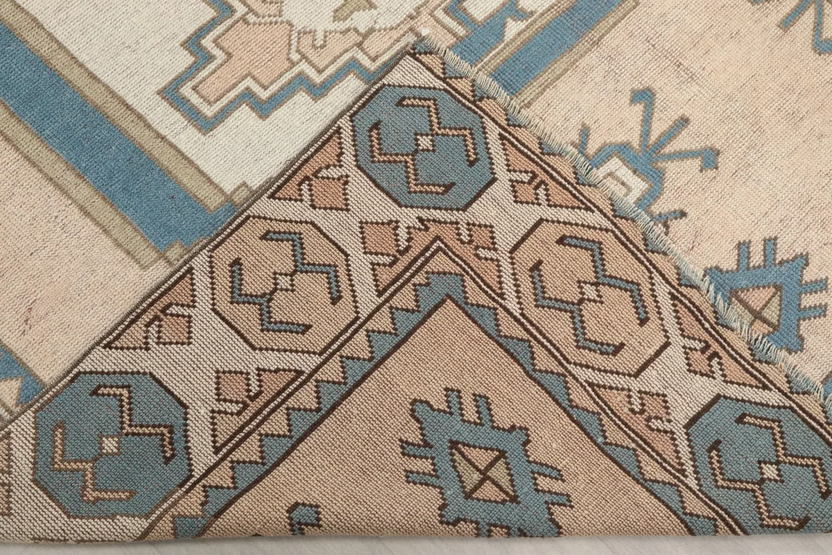 Folded corner of the rug, revealing the backing and the thickness of the wool pile