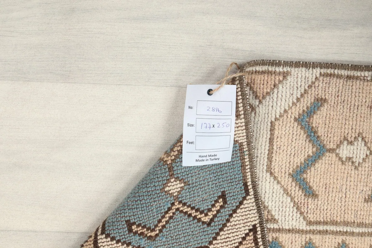 Close-up of the rug's label with size information, next to the hand-knotted edge
