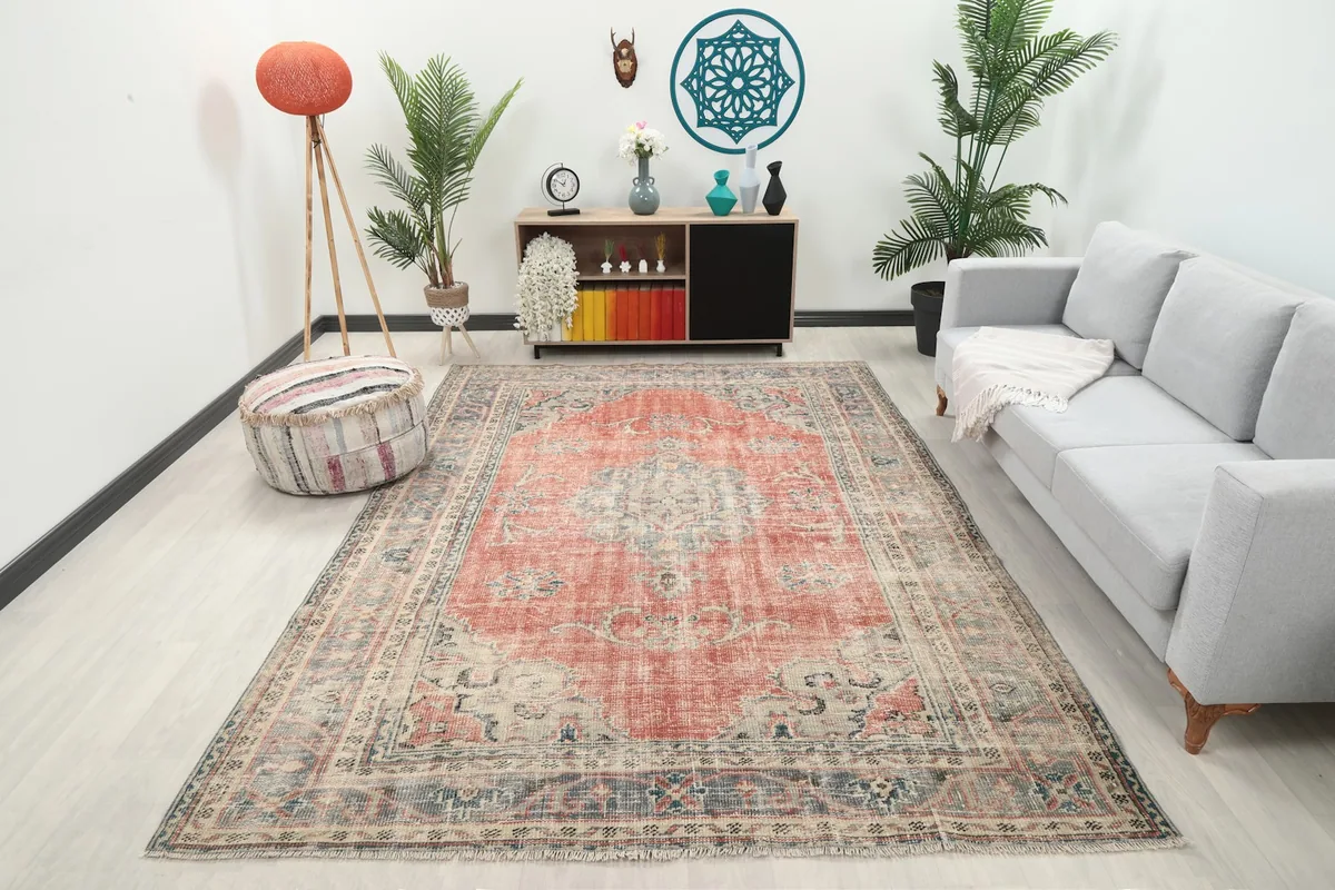 Vintage rust area rug displayed in a bright living room with a gray sofa