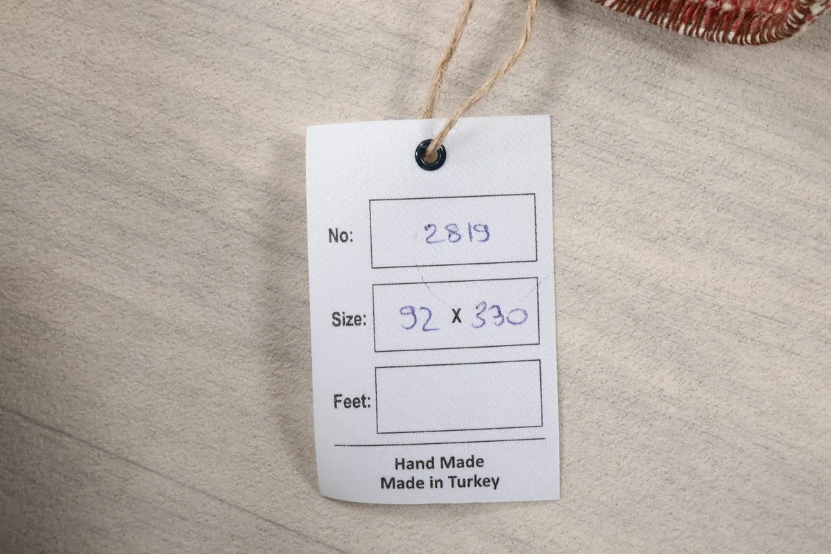 Product tag displaying the rug's unique number and size in centimeters.