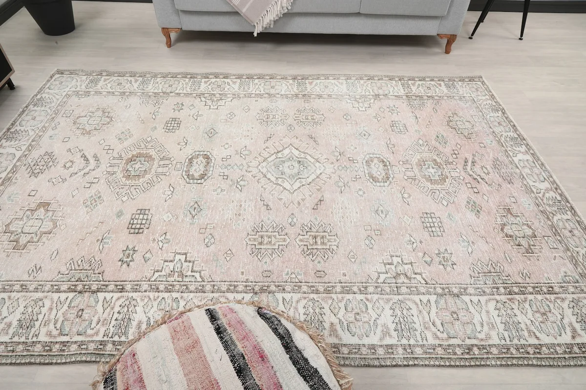 Overhead view of the rug in a room with a pouf in the foreground
