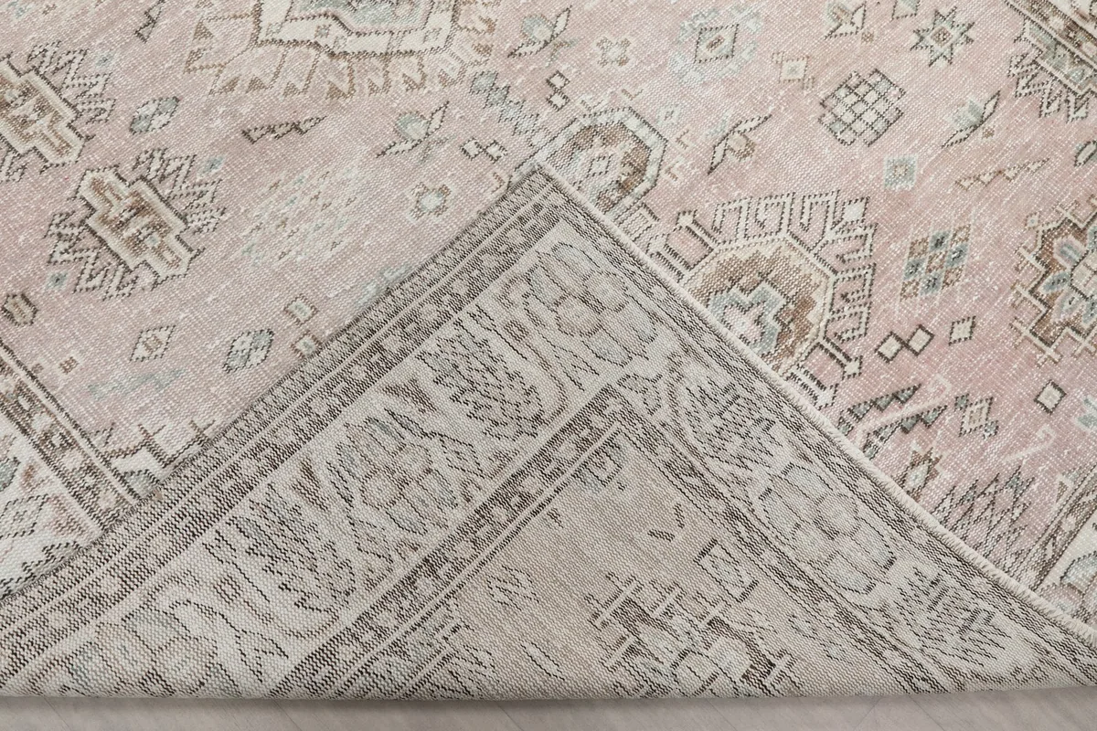 Folded corner of the rug revealing the back of the hand-knotted cotton foundation